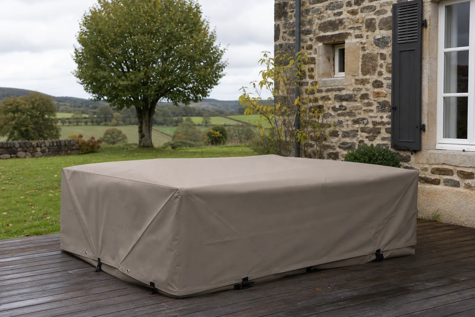 Housse Oxford sanglée sur un salon de jardin, coutures et œillets visibles