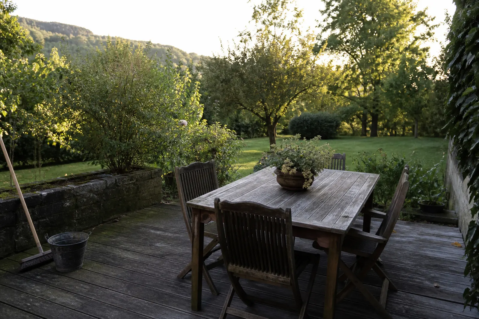 Terrasse de jardin en fin d’été, film vert au nord, table encore dehors