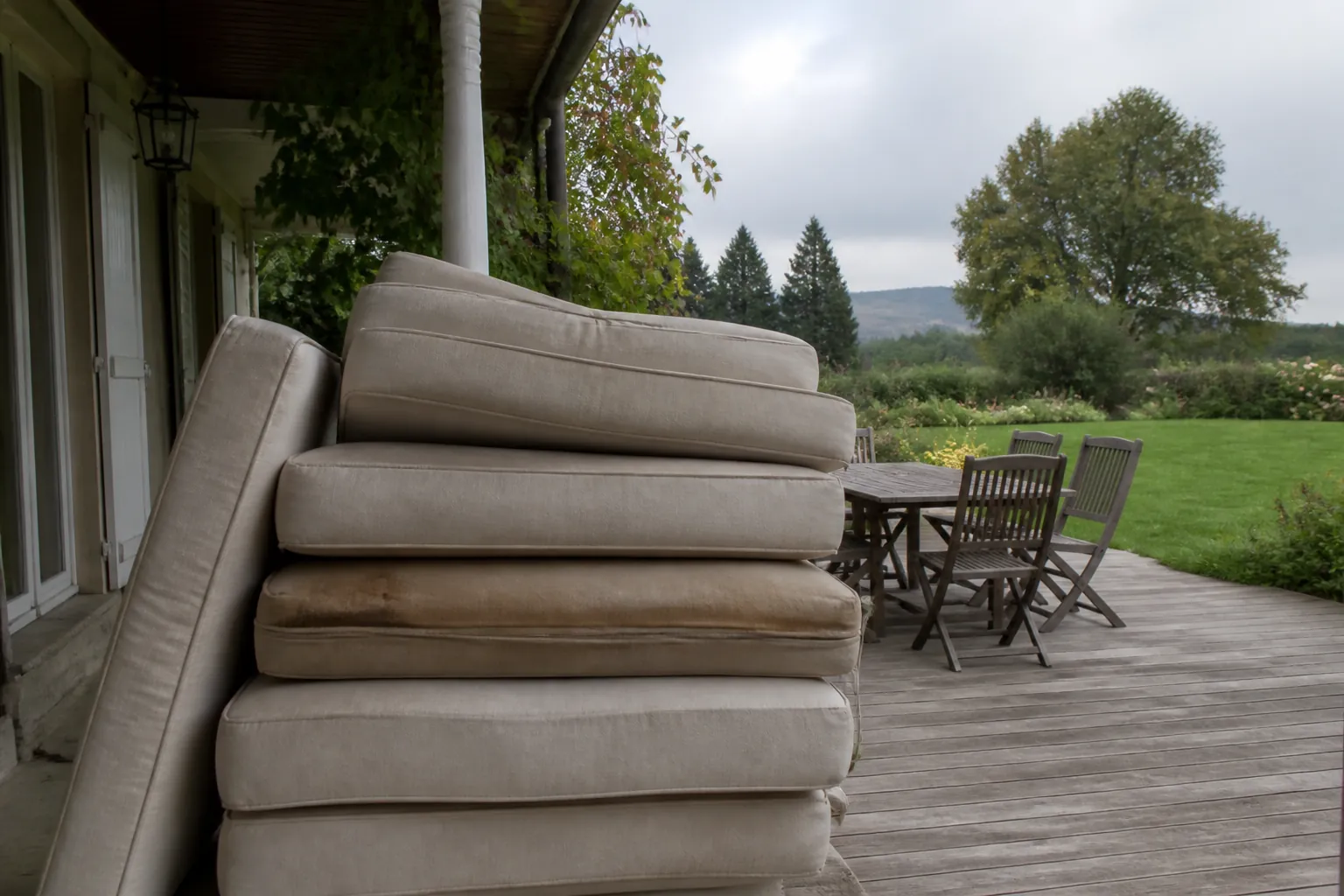 Coussins de salon de jardin empilés à l’abri avant les pluies de septembre